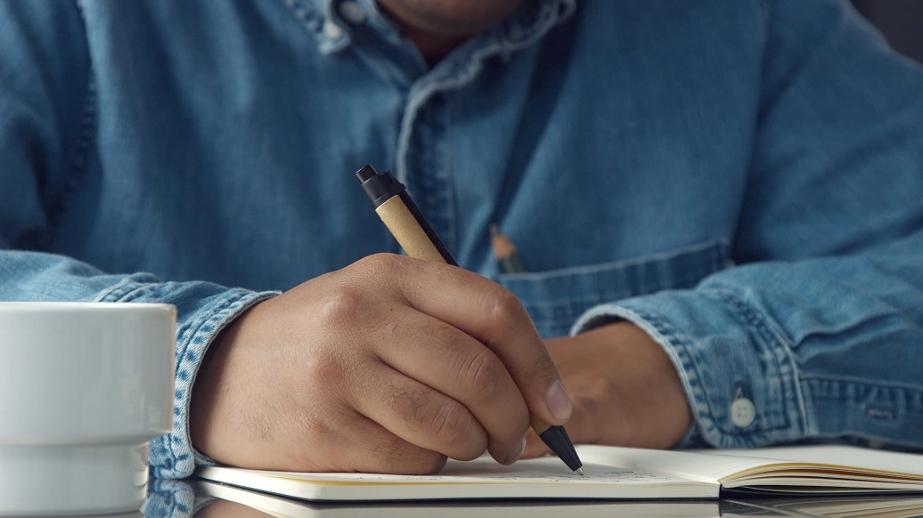 storyblocks-closeup-mans-hands-making-notes-1036x