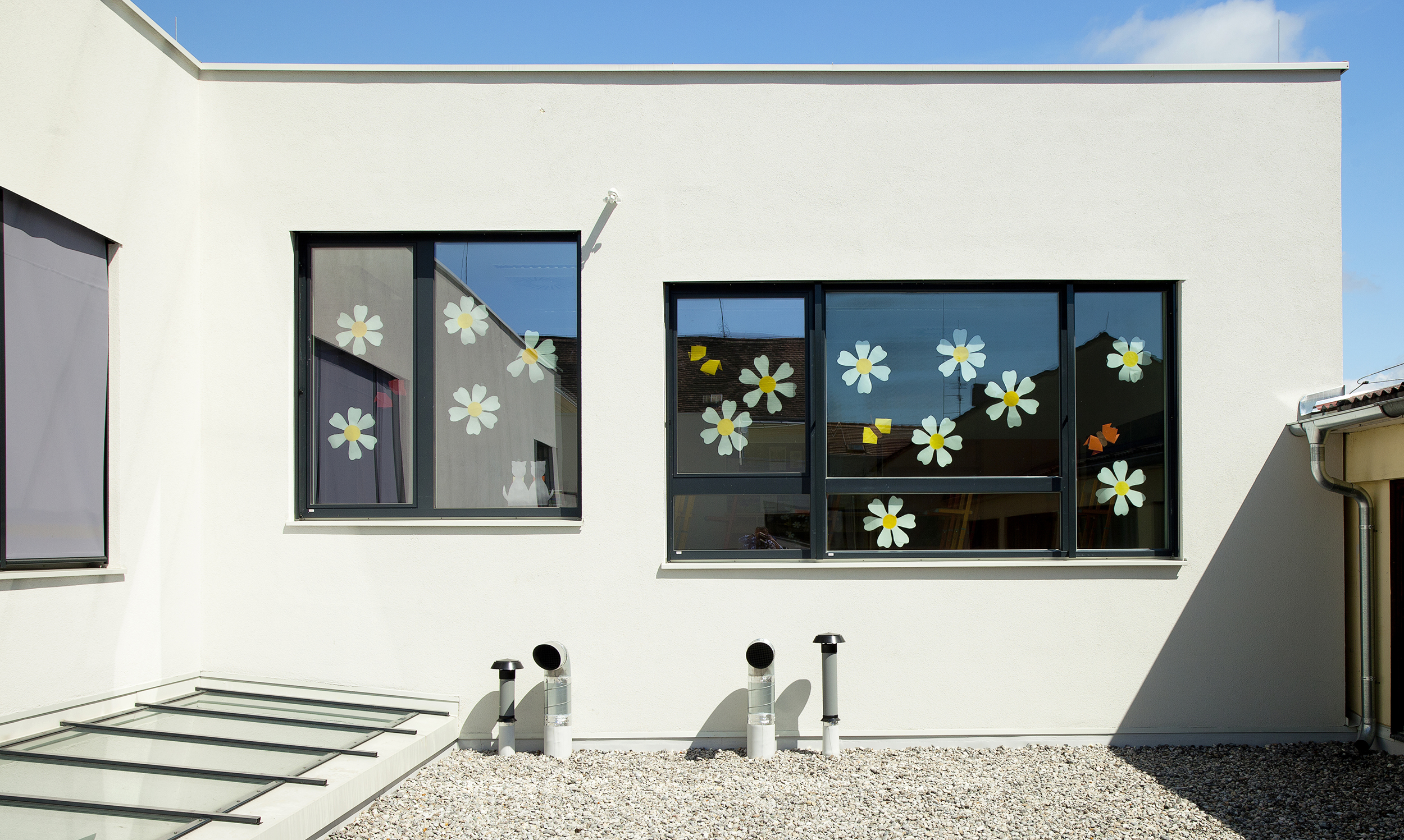 exterior windows, decorated with paper flowers, above a roof