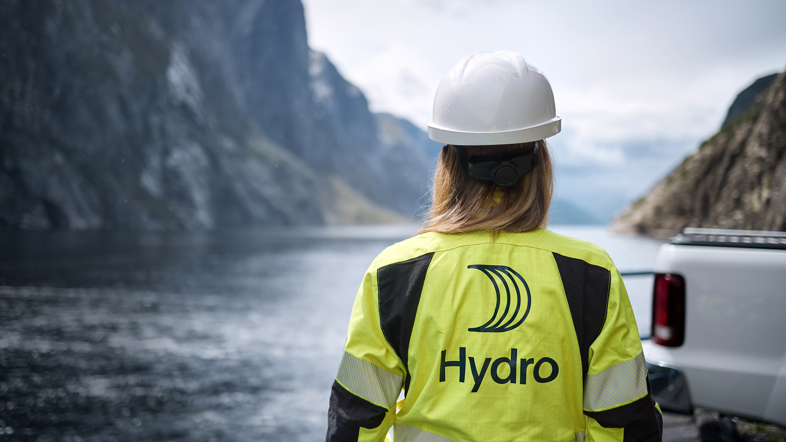 A woman wearing a hard hat and a yellow Hydro jacket