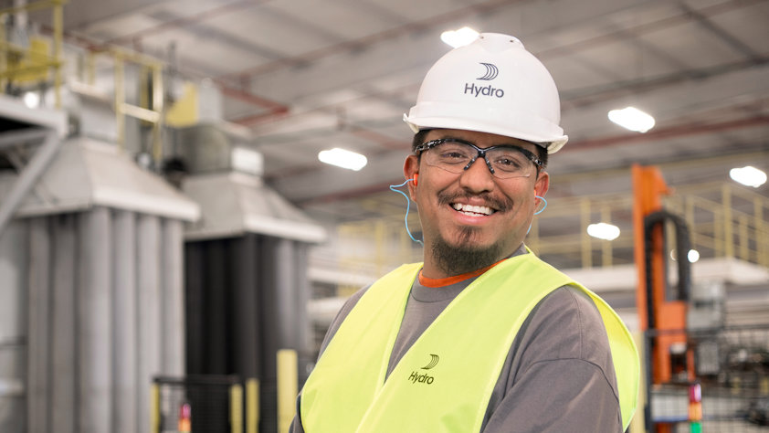 a man wearing a safety vest and a white hard hat