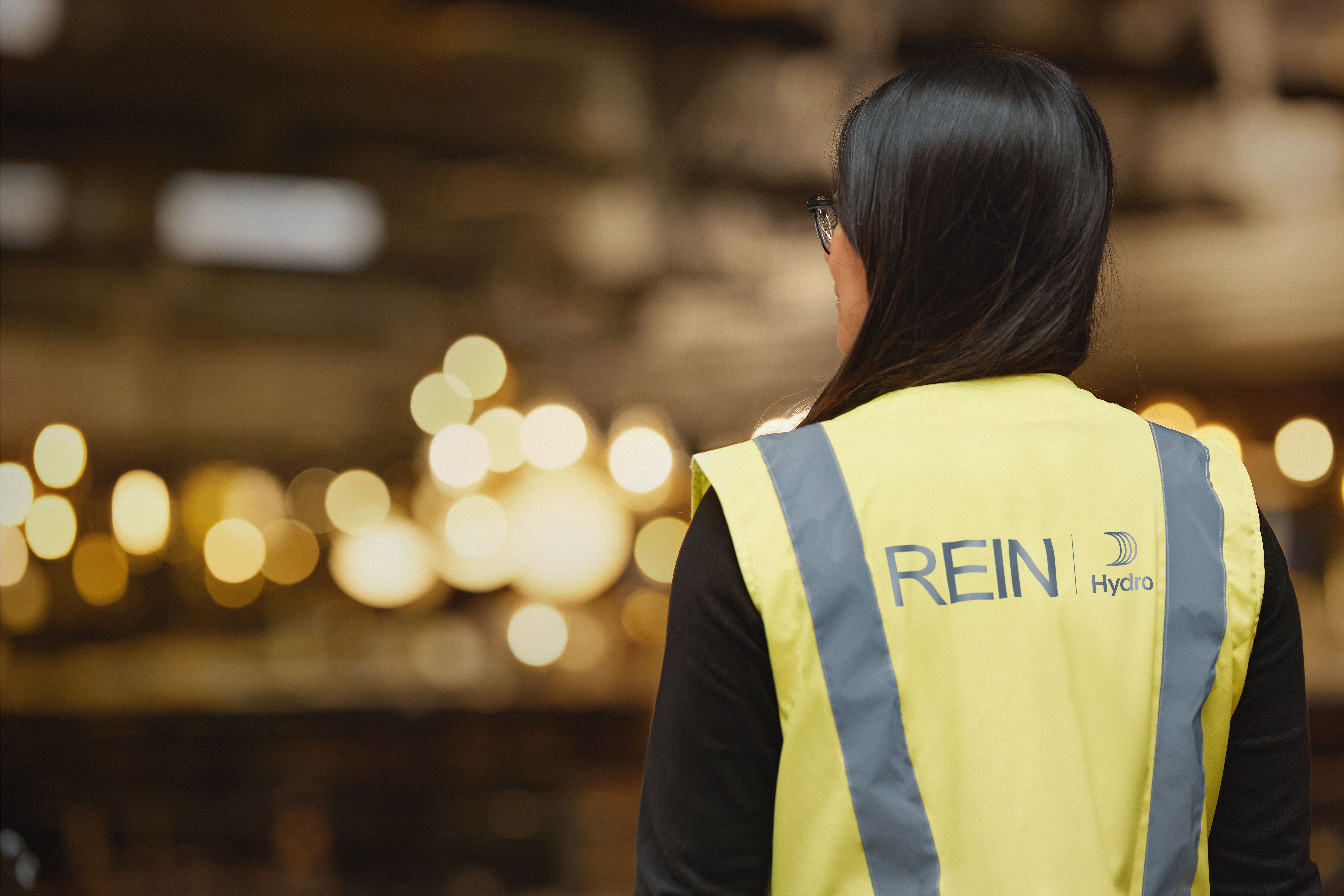 back of a person wearing a yellow jacket with blue text