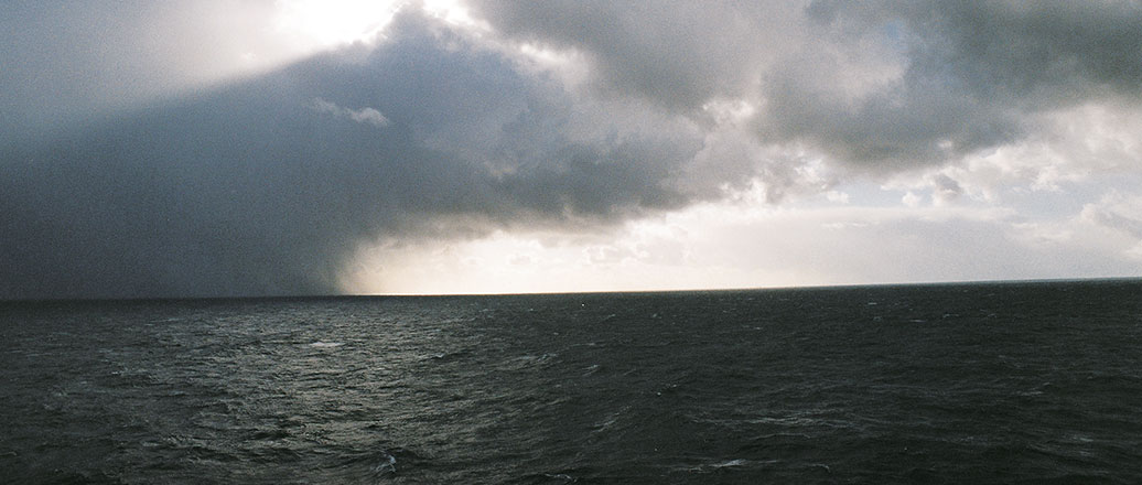 a body of water with clouds above it