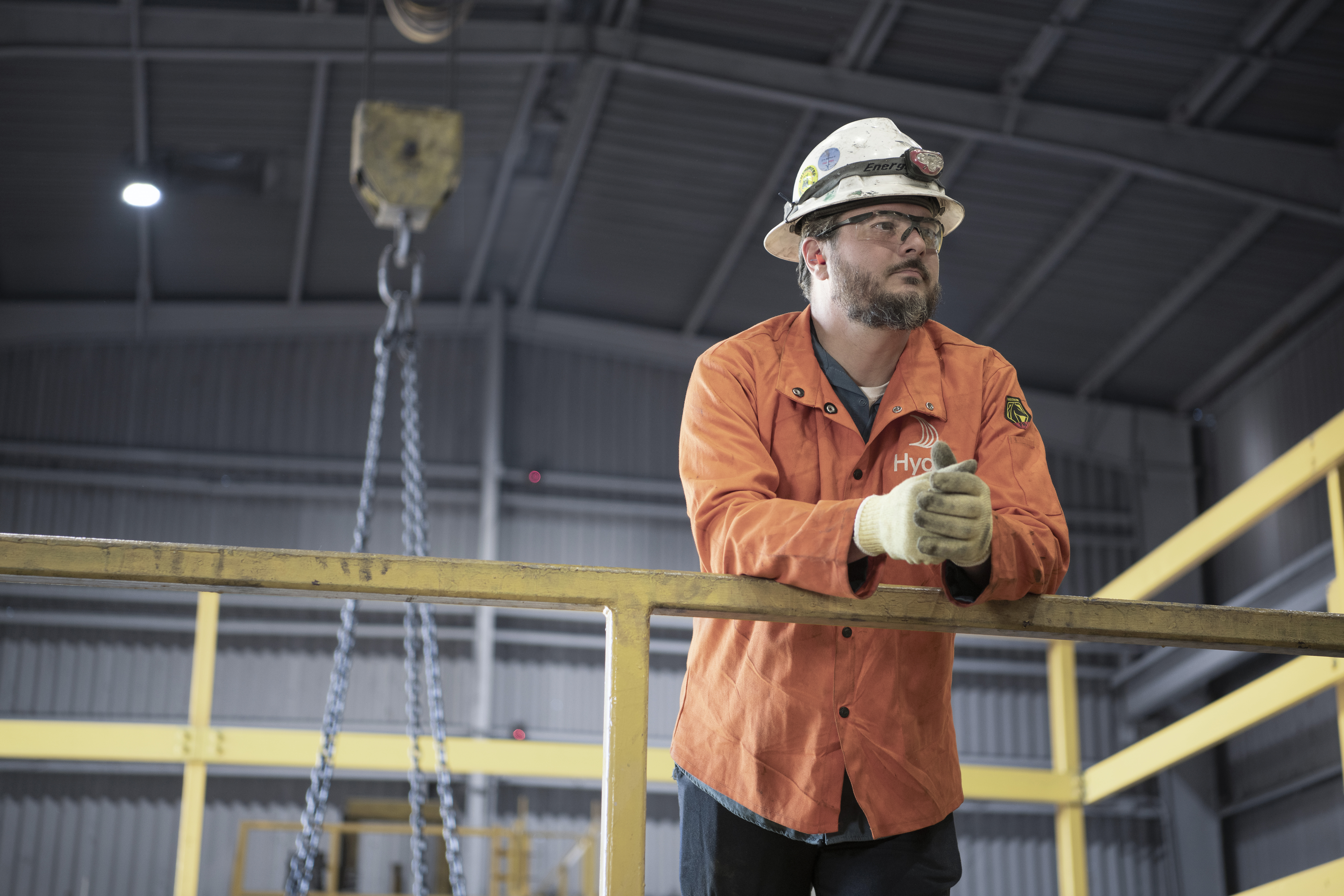 A Hydro employee wearing a safety helmet leaning to a handrail at Hydro Phoenix