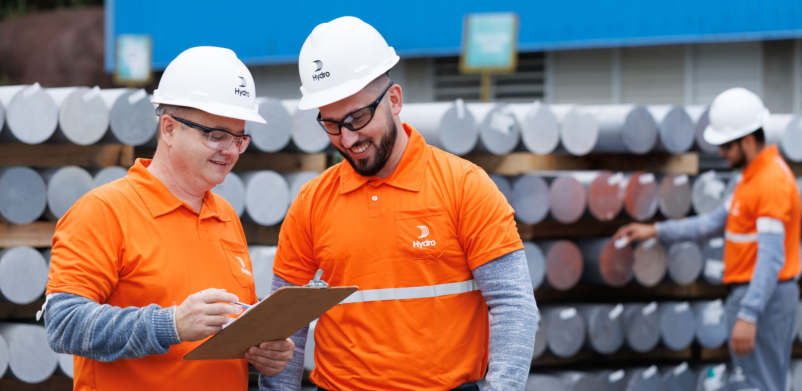 a group of men wearing hardhats and looking at a piece of paper