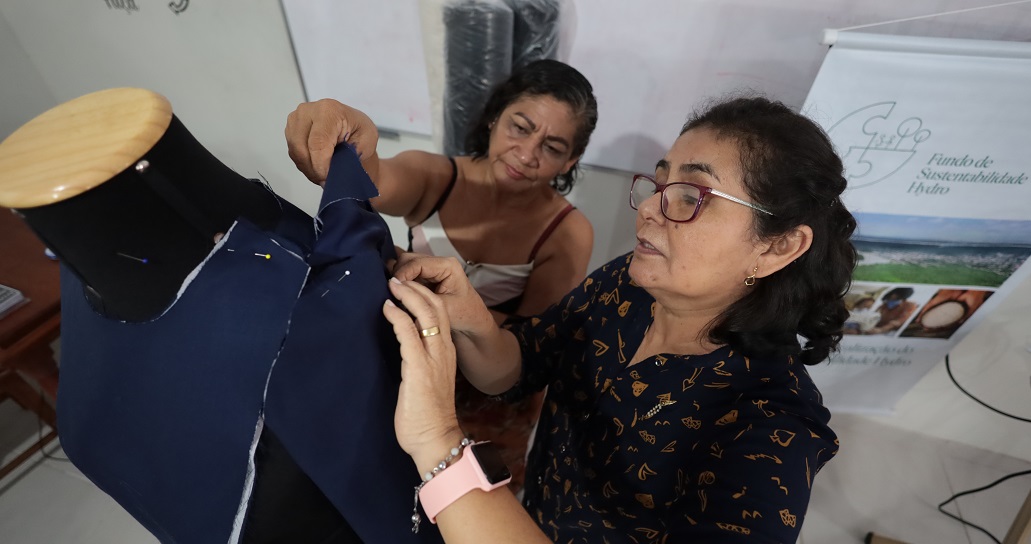 a person holding a blue and black jacket over the shoulder